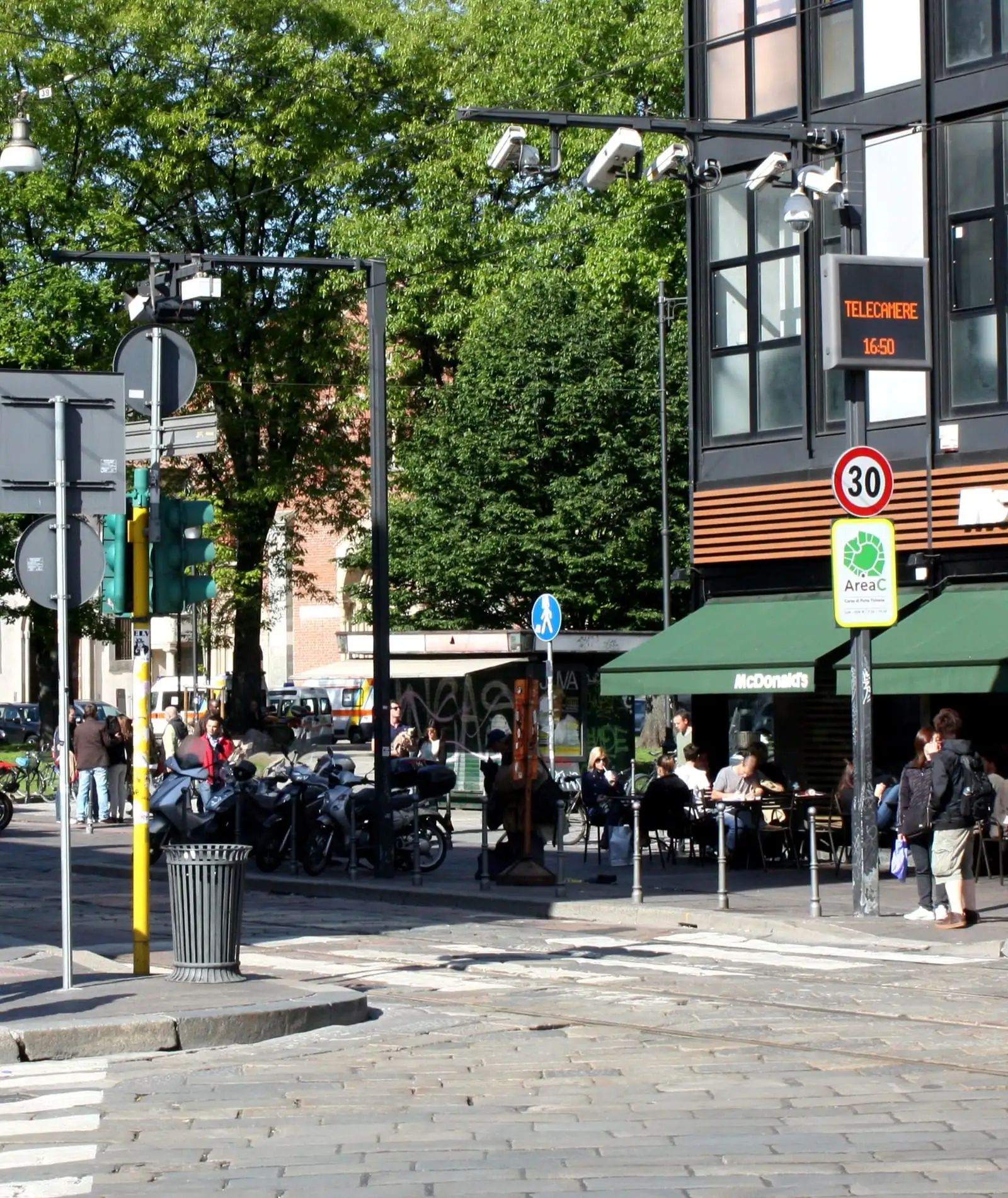 Area C entry gate at Piazza XXIV Maggio in Milan, with cameras on a gantry, an Area C sign and a 30 km/h limit