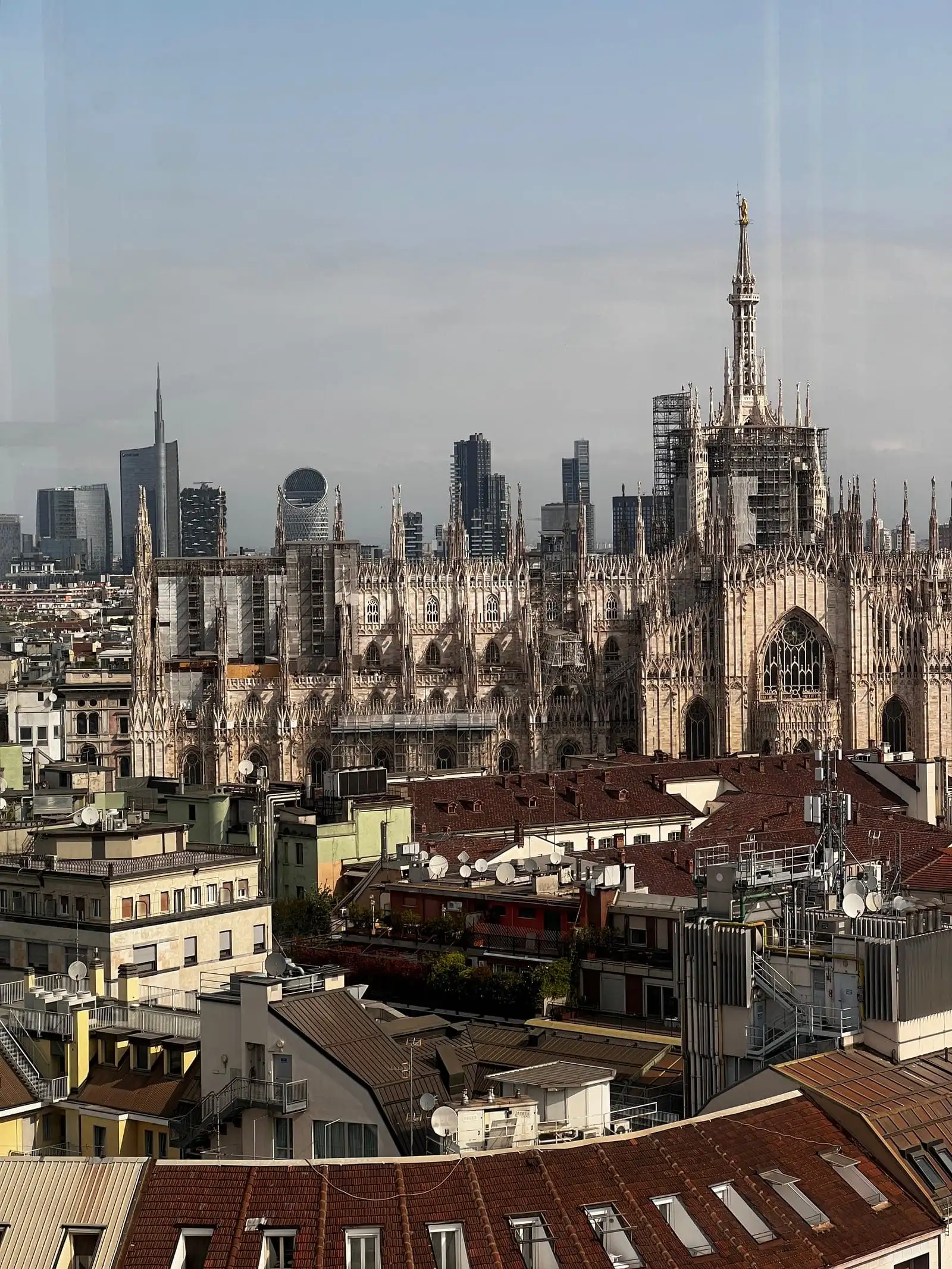 The spires of the Duomo and the Porta Nuova towers rising over the rooftops of central Milan