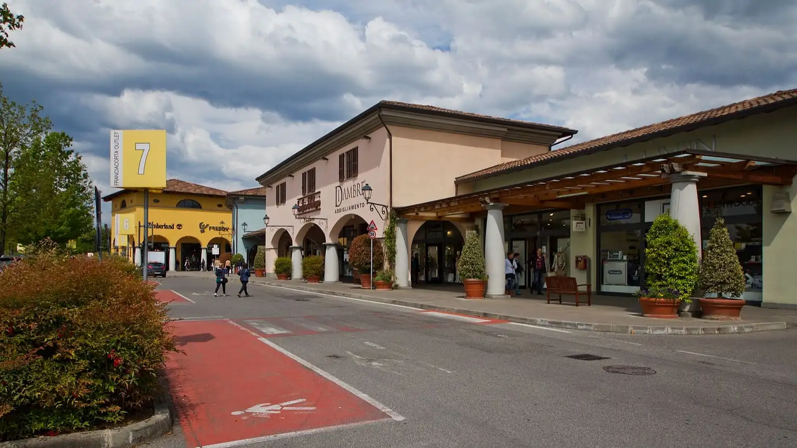 Low arcaded shop buildings and a car-free street at Franciacorta outlet village