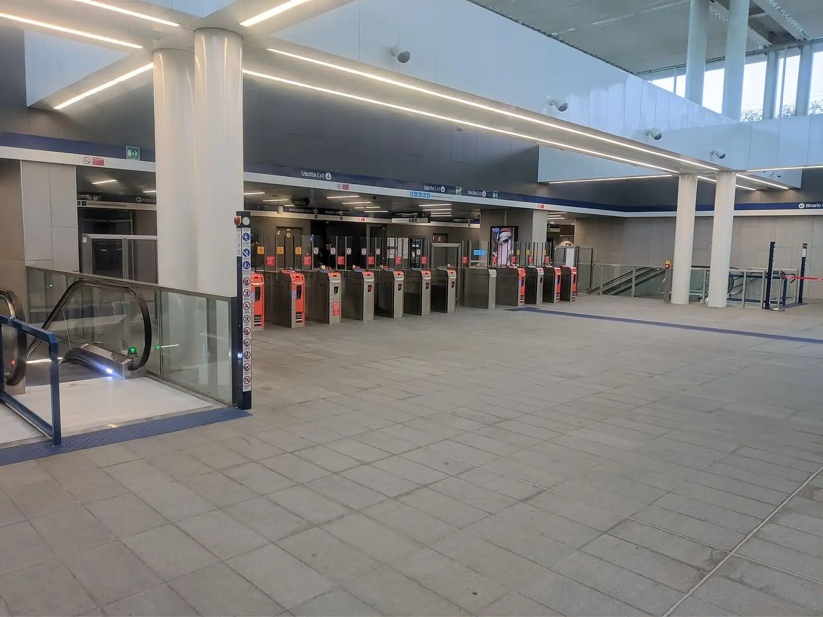 Ticket gates and escalators in the mezzanine of Linate Aeroporto M4 station