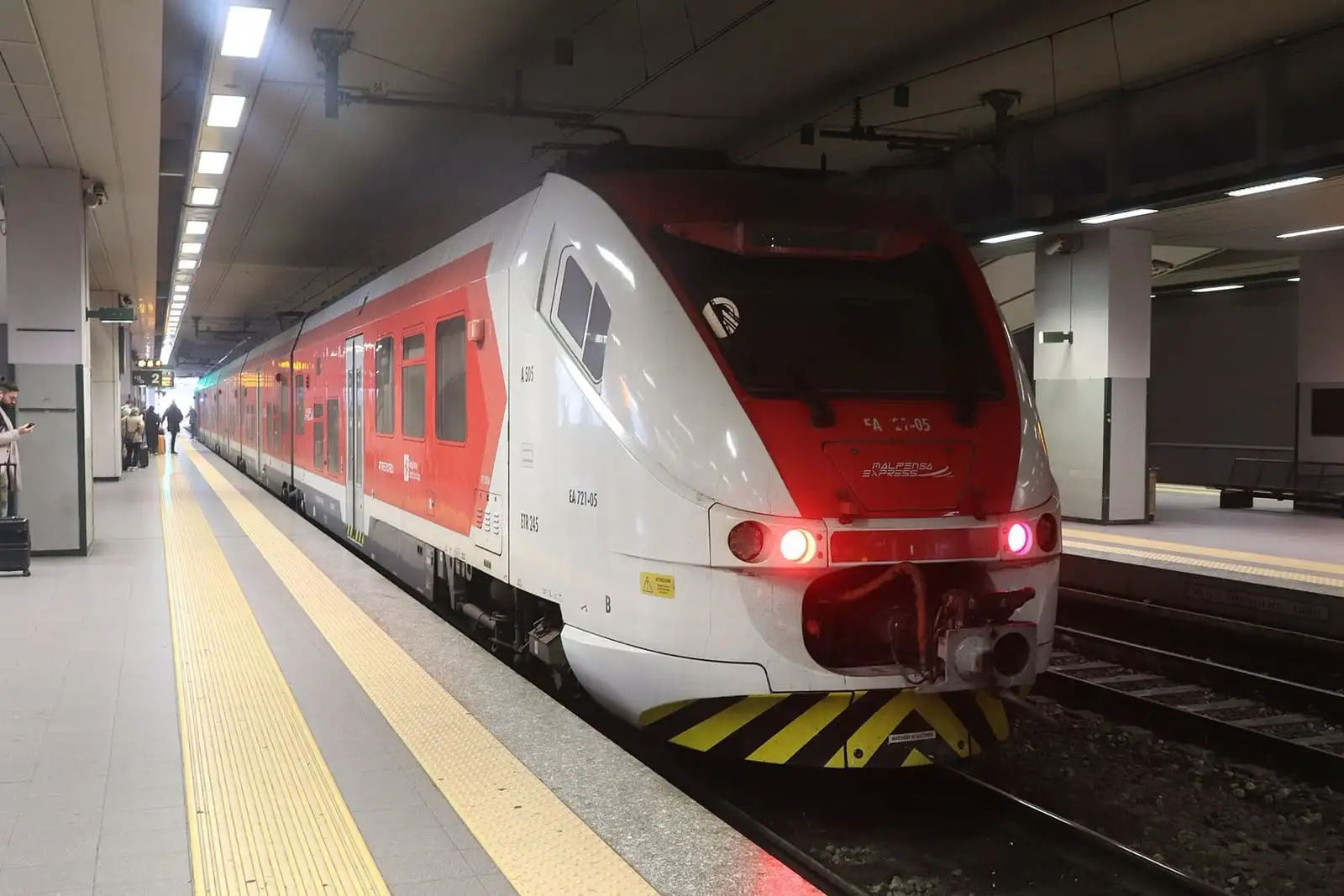 Red and white Trenord Malpensa Express train at the Malpensa Airport Terminal 1 station platform