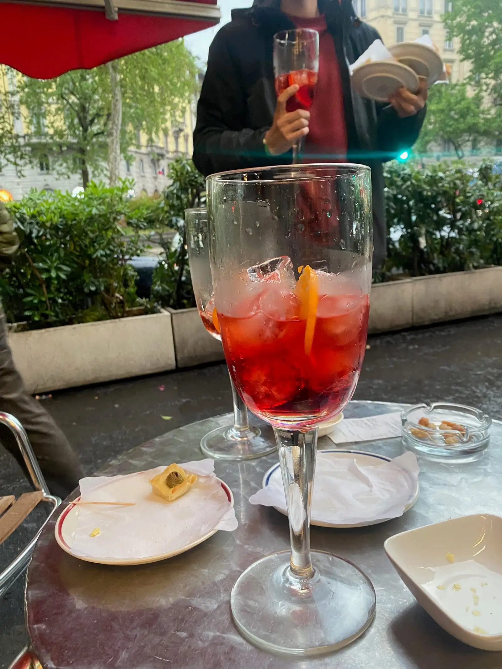 A red spritz with snacks on an outdoor café table