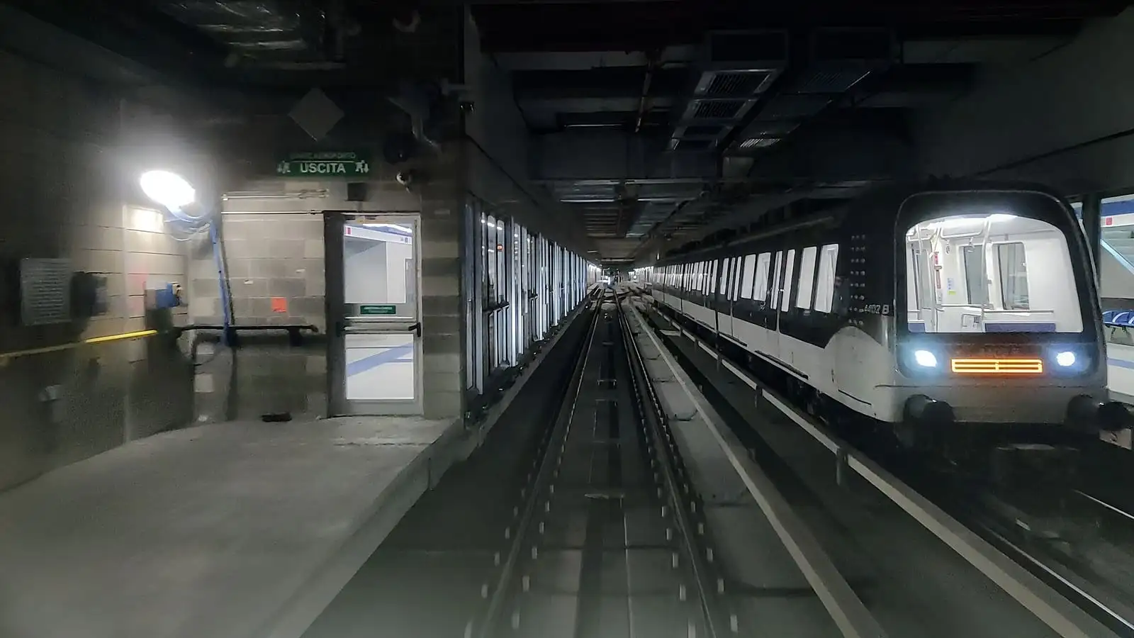 Driverless M4 metro train standing at an underground platform in Milan