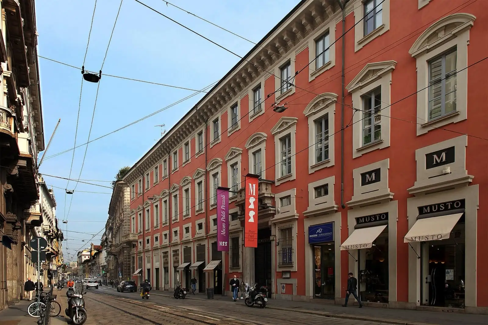 Red-plastered palazzo on Via Manzoni in Milan with the Museo Poldi Pezzoli banners at the entrance