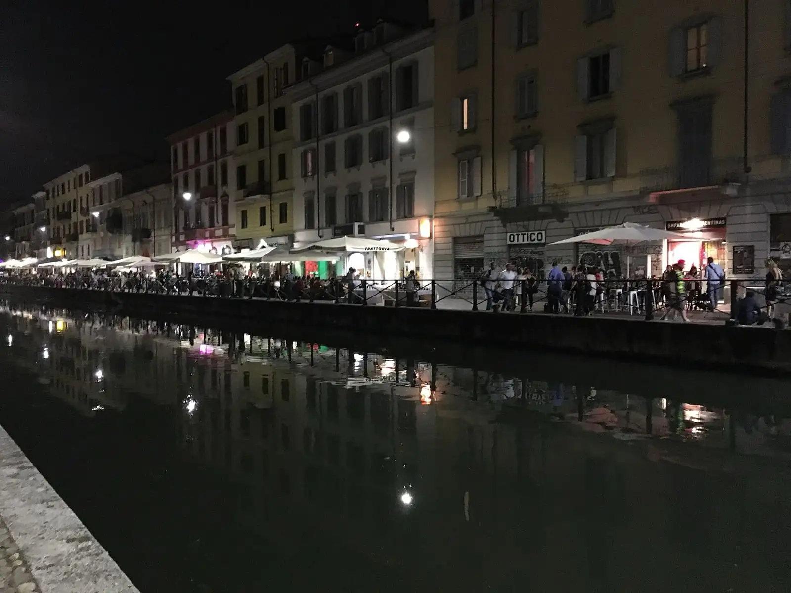 Naviglio Grande canal at night with lit bars and restaurants along both banks