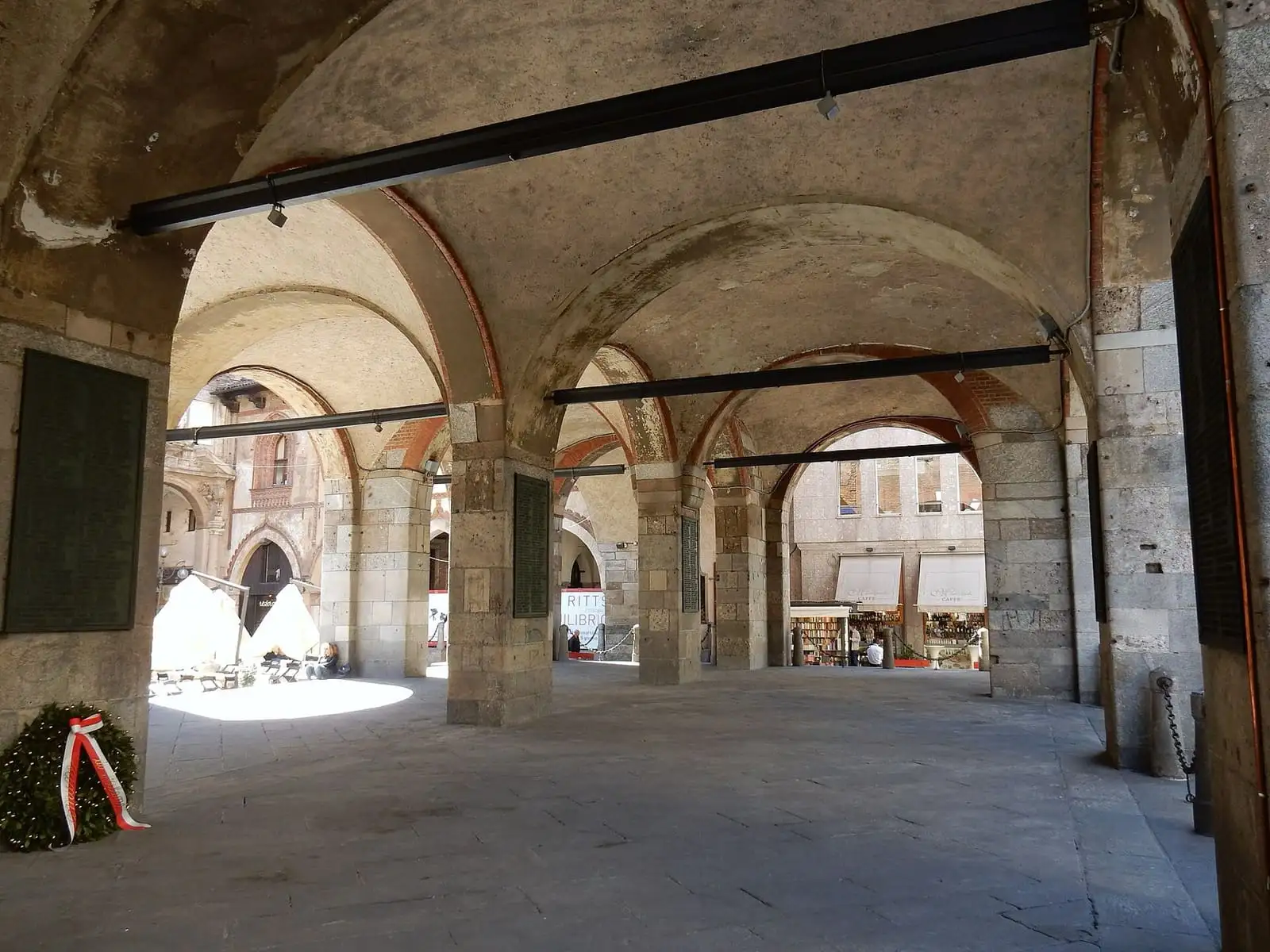 The vaulted stone arcade under the Palazzo della Ragione in Piazza dei Mercanti, Milan