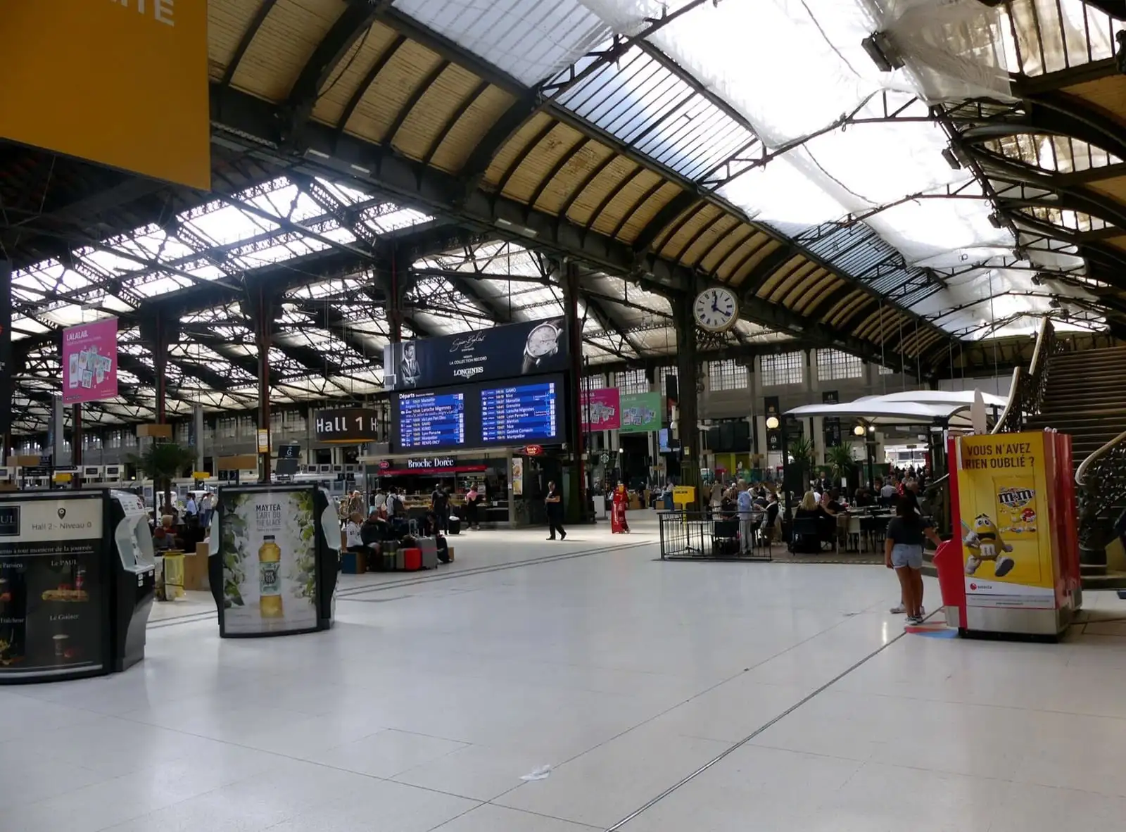 The glass and iron roof over the main hall of Paris Gare de Lyon, with departure boards and cafés