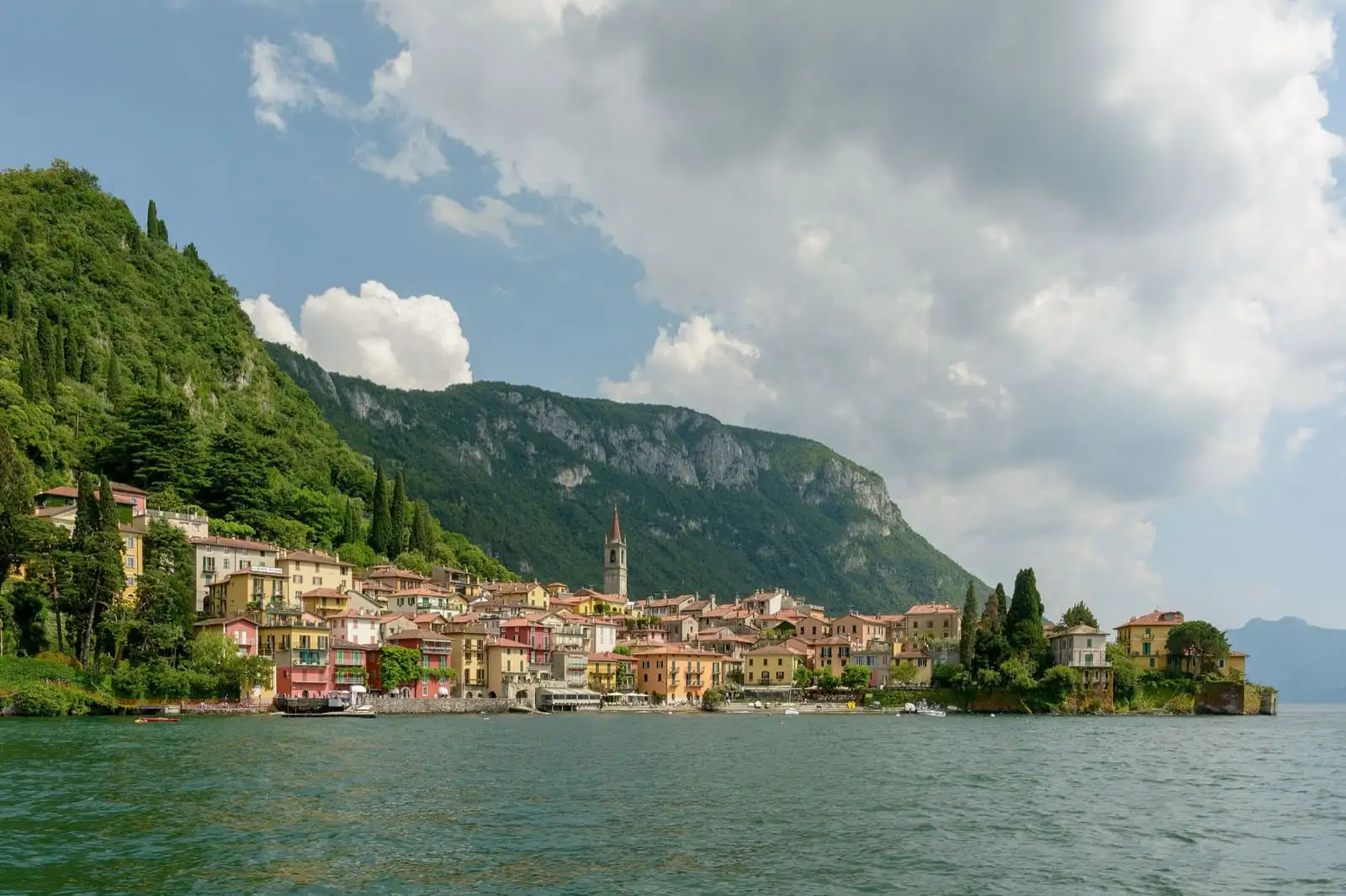 Colourful houses of Varenna on the shore of Lake Como, beneath wooded mountains