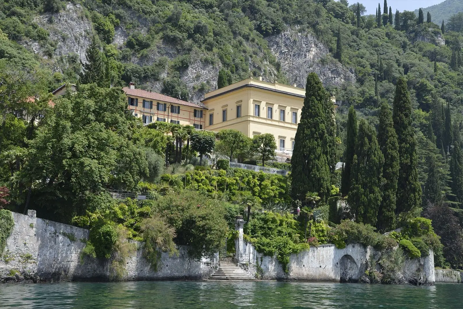Villa Cipressi in Varenna seen from Lake Como, with cypress trees and garden terraces above the water